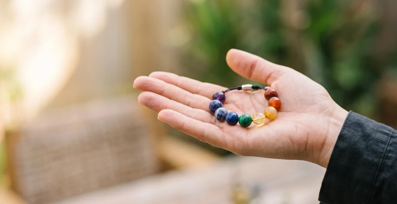 Bracelet en pierres naturelles multicolores posé sur une main ouverte, symbolisant l'équilibre énergétique des sept chakras