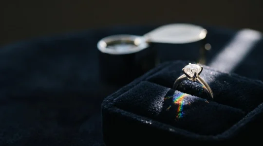 Bague solitaire en diamant posée en gros plan sur un écrin sombre, symbolisant l'achat éclairé et sécurisé d'un bijou de valeur