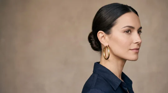 Portrait éditorial d'une femme élégante portant de grandes créoles dorées sans excès