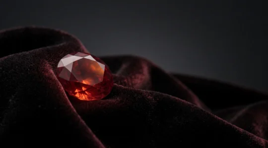 Gros plan artistique d'un rubis rouge intense évoquant la passion et le pouvoir à travers les siècles